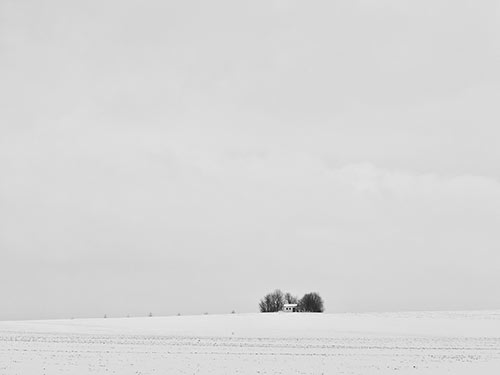 snowy landdscape with one building in the disctance